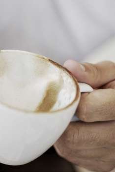 Close-up of a person´s hand holding a coffee cup