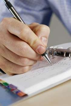 Close-up of a person´s hand writing in a diary