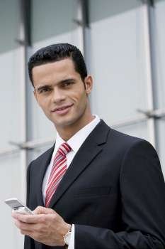 Portrait of a businessman holding a mobile phone and smiling