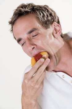 Close-up of a mid adult man eating a fruit tart