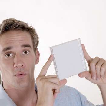 Portrait of a mid adult man holding a CD case
