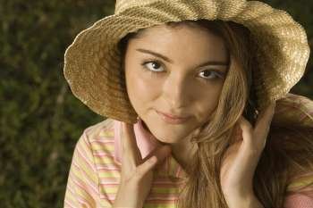 Portrait of a young woman wearing a straw hat
