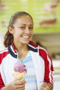 Portrait of a young woman holding an ice-cream and smiling