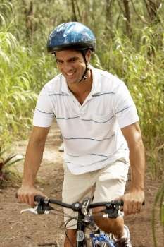 Mid adult man riding a bicycle and smiling