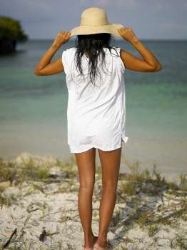 Rear view of a young woman standing on the beach