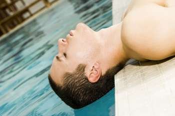 Close-up of a young man lying at the poolside