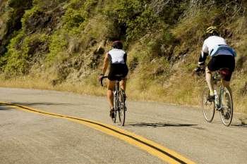 Rear view of two people cycling