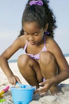 Close-up of a girl playing with sand on the beach