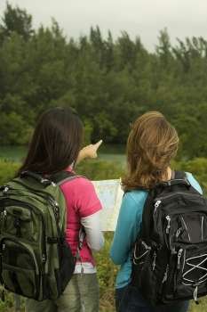 Rear view of two women looking at a map