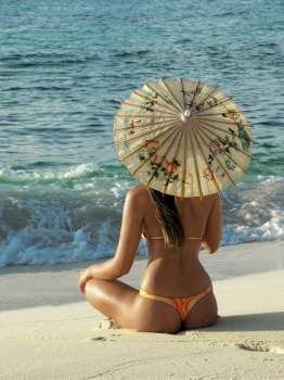 Rear view of a young woman sitting on the beach