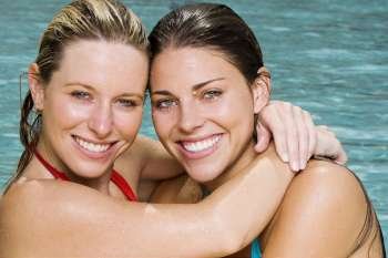 Portrait of two young women hugging in a swimming pool