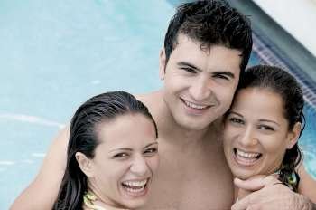 Portrait of two young women and a young man in a swimming pool