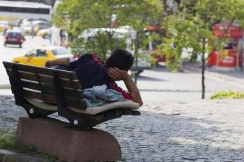 Rear view of a man lying on a park bench, Istanbul, Turkey