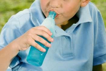 Close-up of a boy drinking water from a bottle