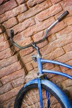 Close-up of a bicycle against a brick wall