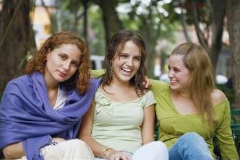 Close-up of three young women sitting together
