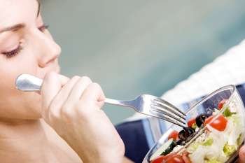 Close-up of a young woman holding a bowl of salad