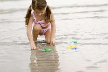 Girl playing with toys on the beach