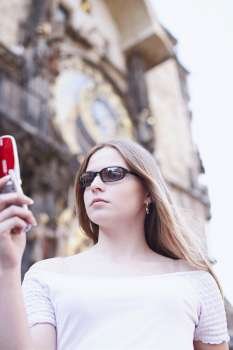 Low angle view of a young woman holding a mobile phone 