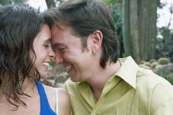 Close-up of a young woman and a mid adult man smiling in a park