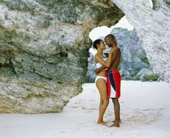 Side profile of a young couple nuzzling on the beach, Bermuda