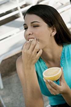 Close-up of a young woman eating citrus fruit