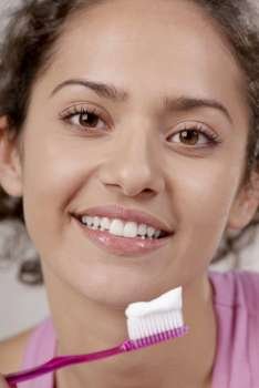 Portrait of a young woman with a toothbrush in front of her mouth