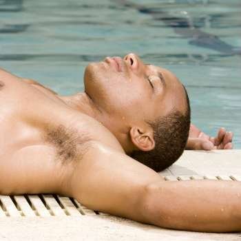 Close-up of a young man lying down at the poolside