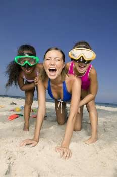 Young woman shouting with two girls on the beach