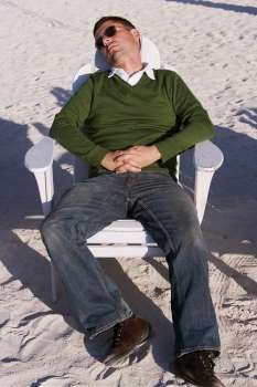 High angle view of a mid adult man reclining on a lounge chair