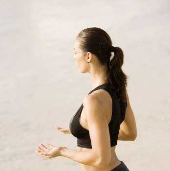 Side profile of a young woman practicing martial arts on the beach