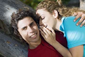 Close-up of a mid adult woman whispering into a mid adult man´s ear