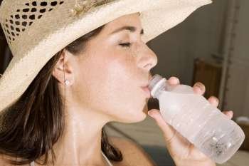 Close-up of a young woman drinking water from a bottle