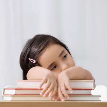Close-up of a girl leaning on books