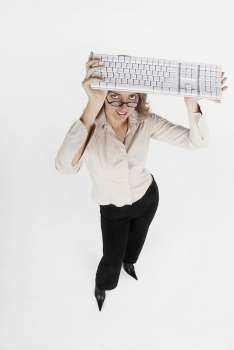 High angle view of a businesswoman holding a computer keyboard over her head
