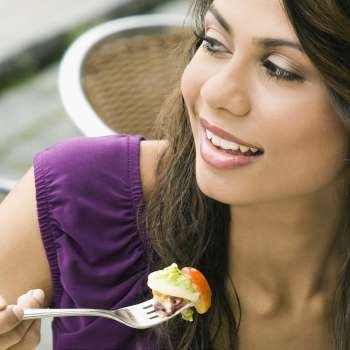 Close-up of a young woman eating salad
