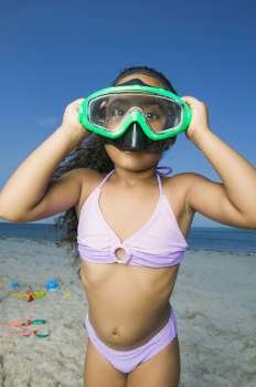 Close-up of a girl standing on the beach and wearing a scuba mask
