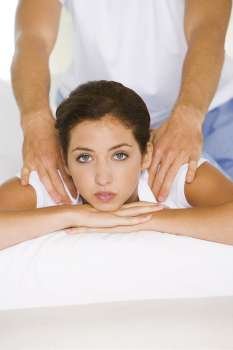 Portrait of a young woman getting a shoulder massage
