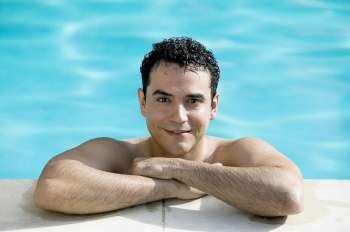 Portrait of a young man smiling in a swimming pool