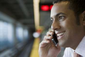 Close-up of a businessman talking on a mobile phone at a subway station