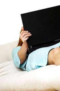 Businesswoman lying on a couch with a laptop