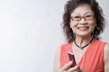 Portrait of a senior woman listening to an MP3 player and smiling