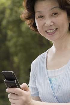 Portrait of a mature woman operating a mobile phone and smiling