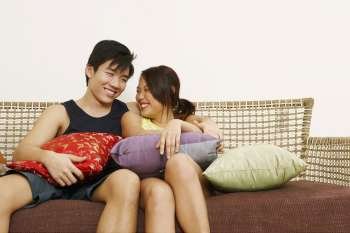 Young couple sitting on a couch and smiling