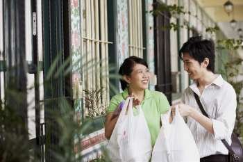 Young couple looking at each other and holding plastic bags