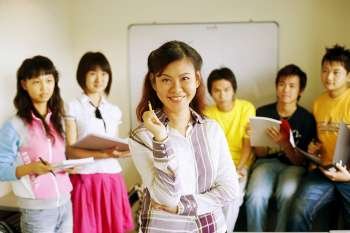 Portrait of a professor smiling with her students in a classroom