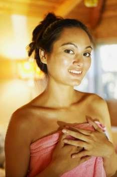 Portrait of a young woman wearing a towel and smiling