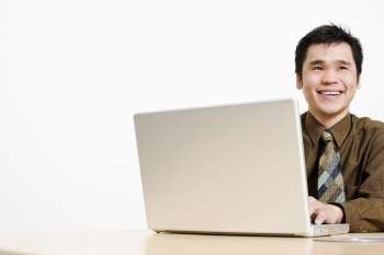 Close-up of a businessman using a laptop and smiling