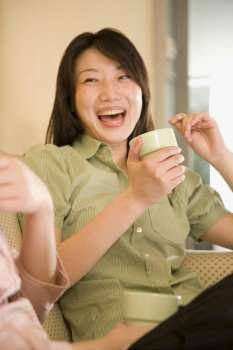 Young woman holding a coffee cup and laughing