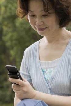 Close-up of a mature woman operating a mobile phone